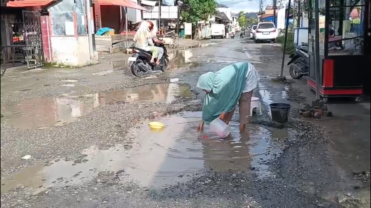 Protes Jalan Rusak, Warga Pulau Tengah Cuci Piring di Tengah Jalan