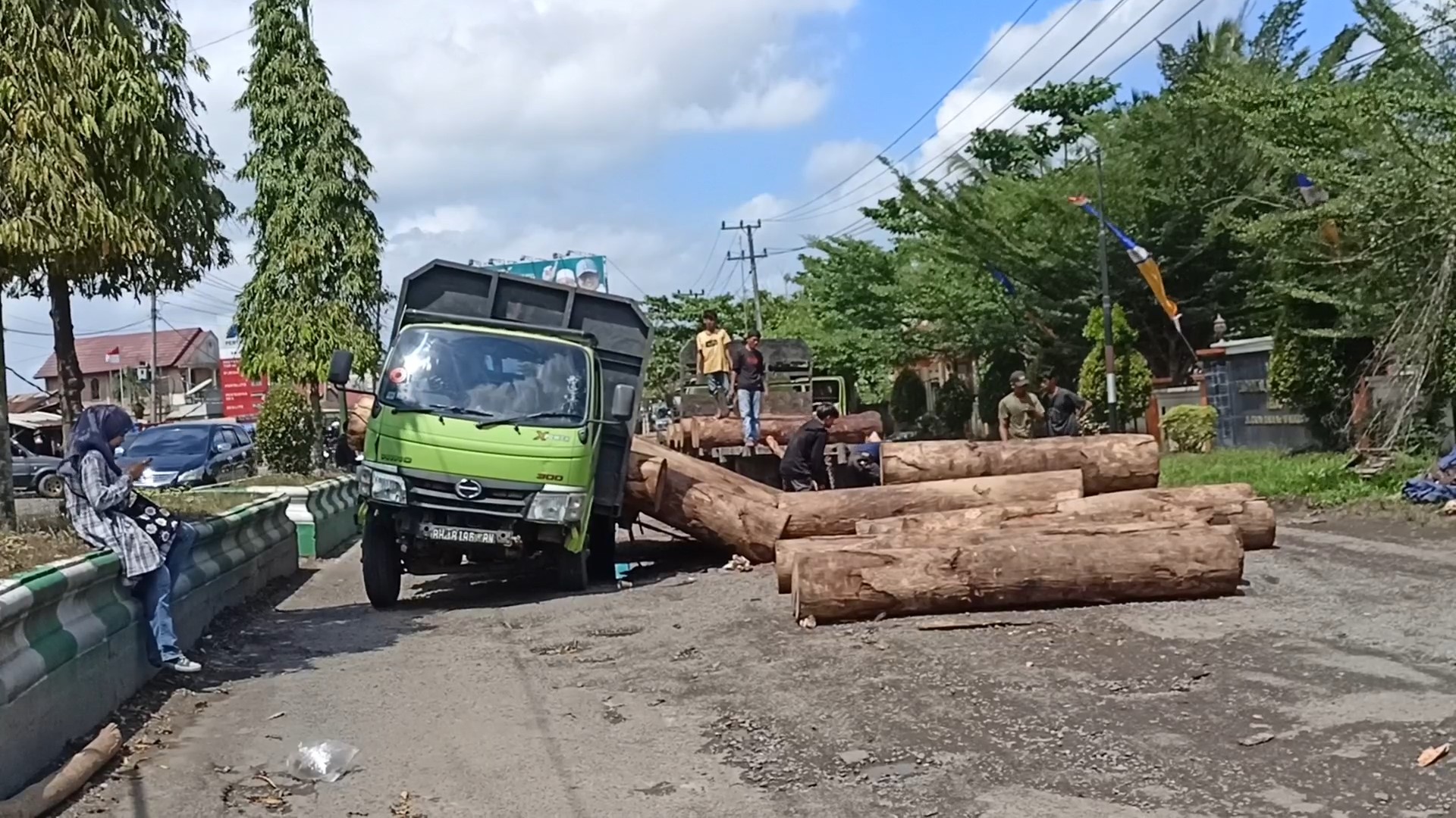 Truk Hantam Lobang Jalan, Muatan Puluhan Balok Kayu Berserakan Menutup Jalan