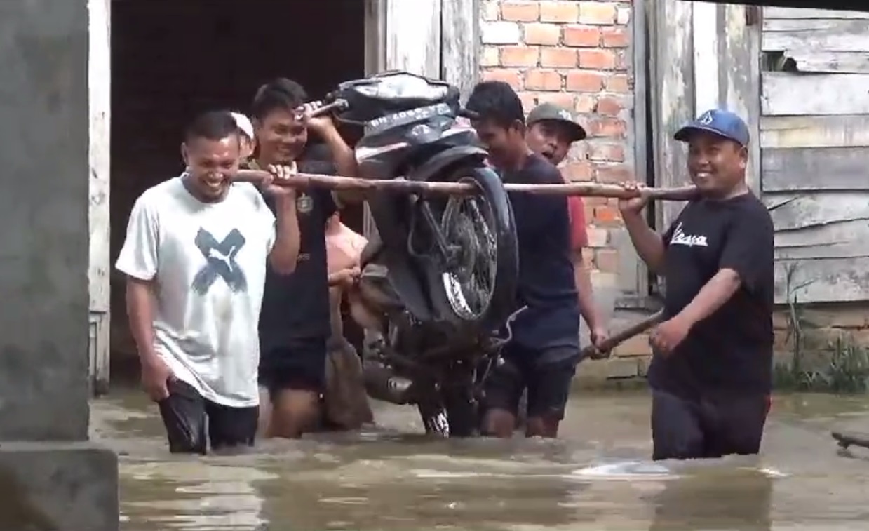 Warga Evakuasi Motor Yang Terjebak Banjir Ke Tempat Yang Lebih Tinggi 