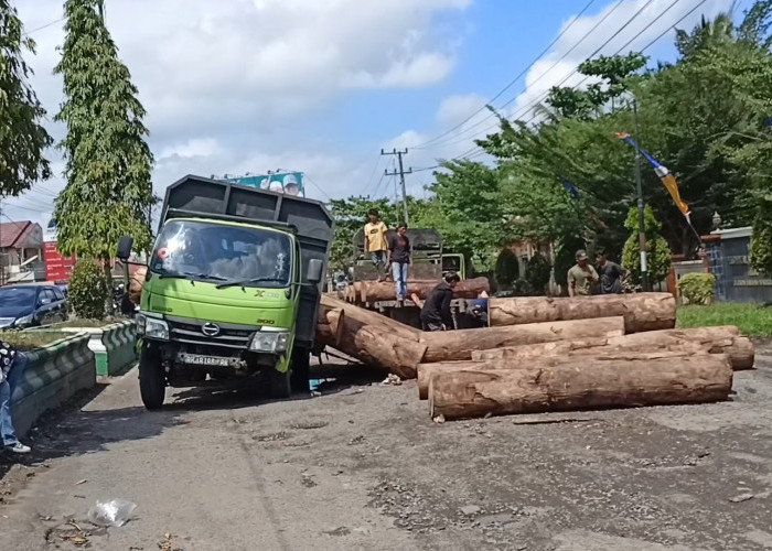 Truk Hantam Lobang Jalan, Muatan Puluhan Balok Kayu Berserakan Menutup Jalan