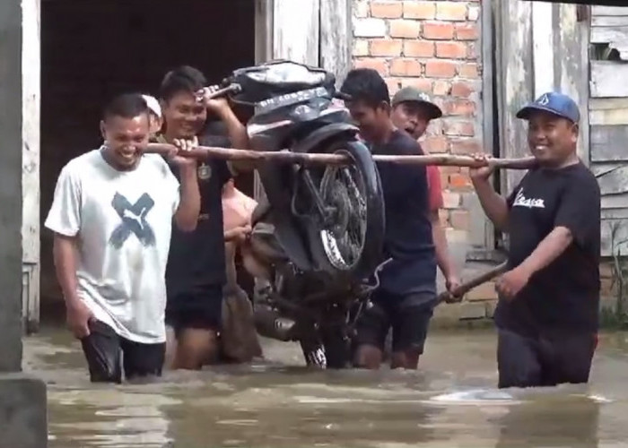 Warga Evakuasi Motor Yang Terjebak Banjir Ke Tempat Yang Lebih Tinggi 